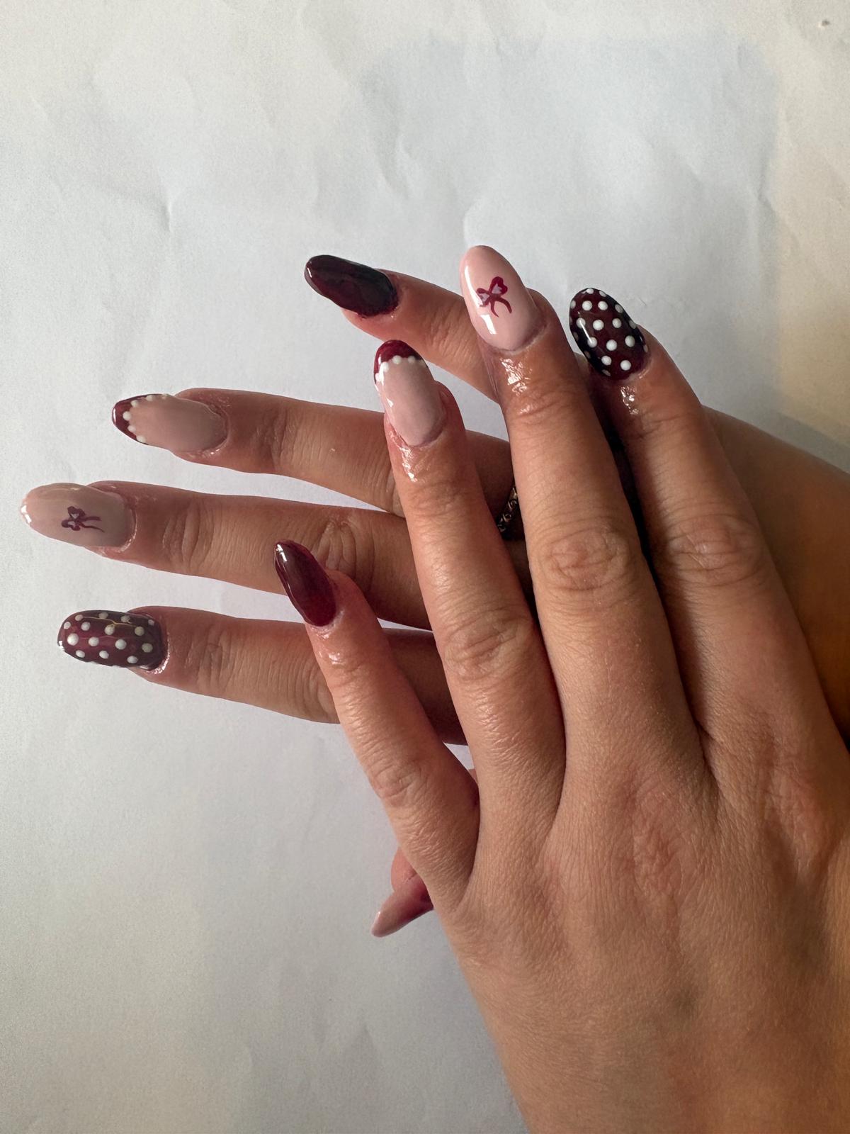 Burgundy and nude nail art with bow accents