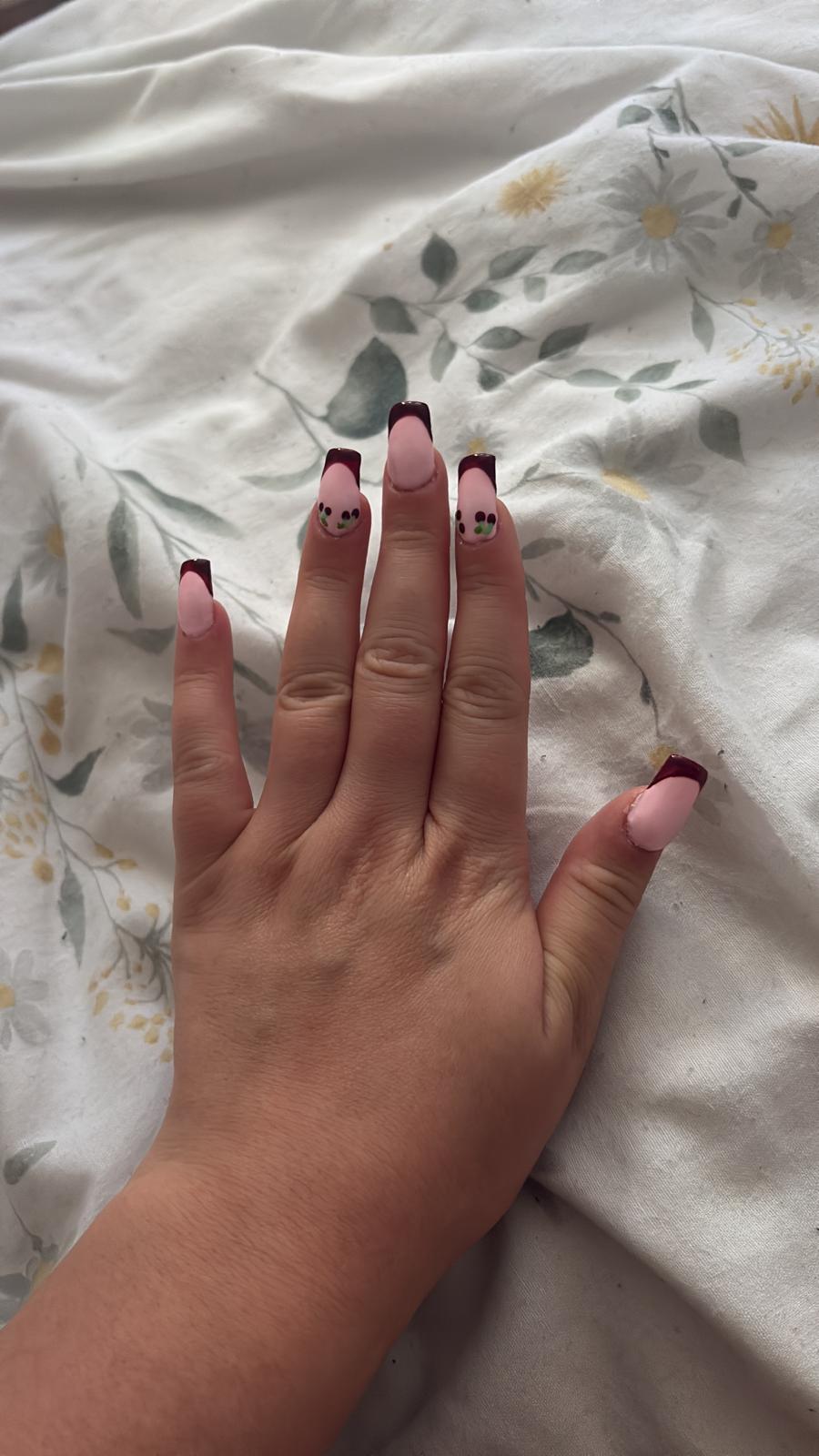 Nude square nails with burgundy French tips and botanical accents